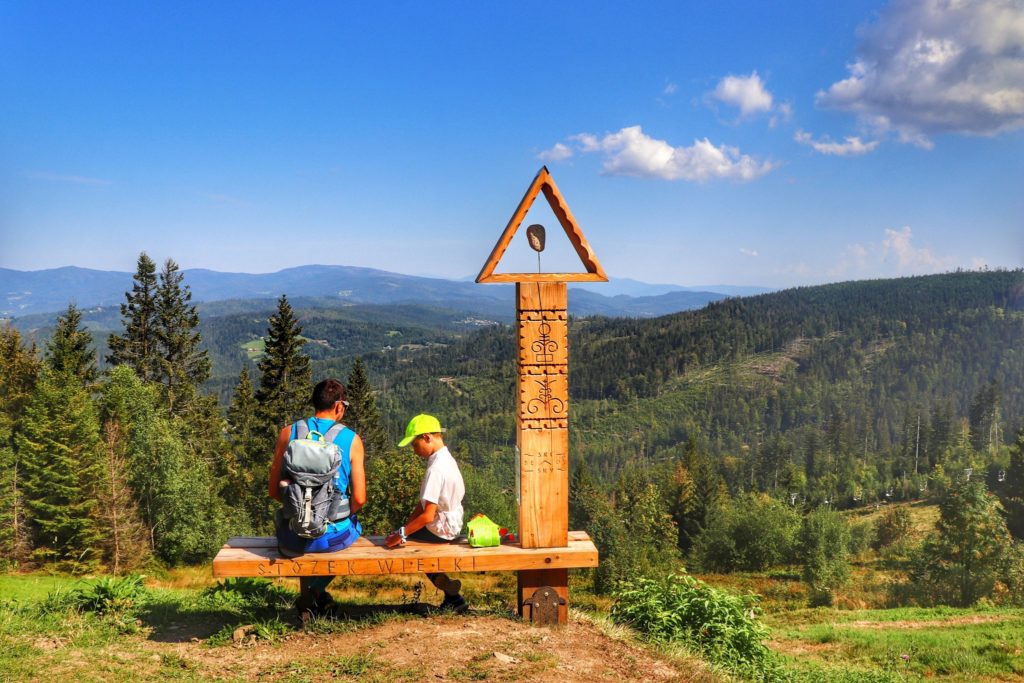 Drewniana ławeczka na Stożku Wielkim w Beskidzie Śląskim, turysta z dzieckiem