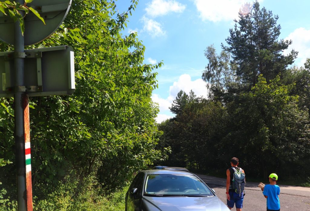 Szlak czerwony na Kiczerę, turysta z dzieckiem, droga asfaltowa, zaparkowany przy drodze samochód