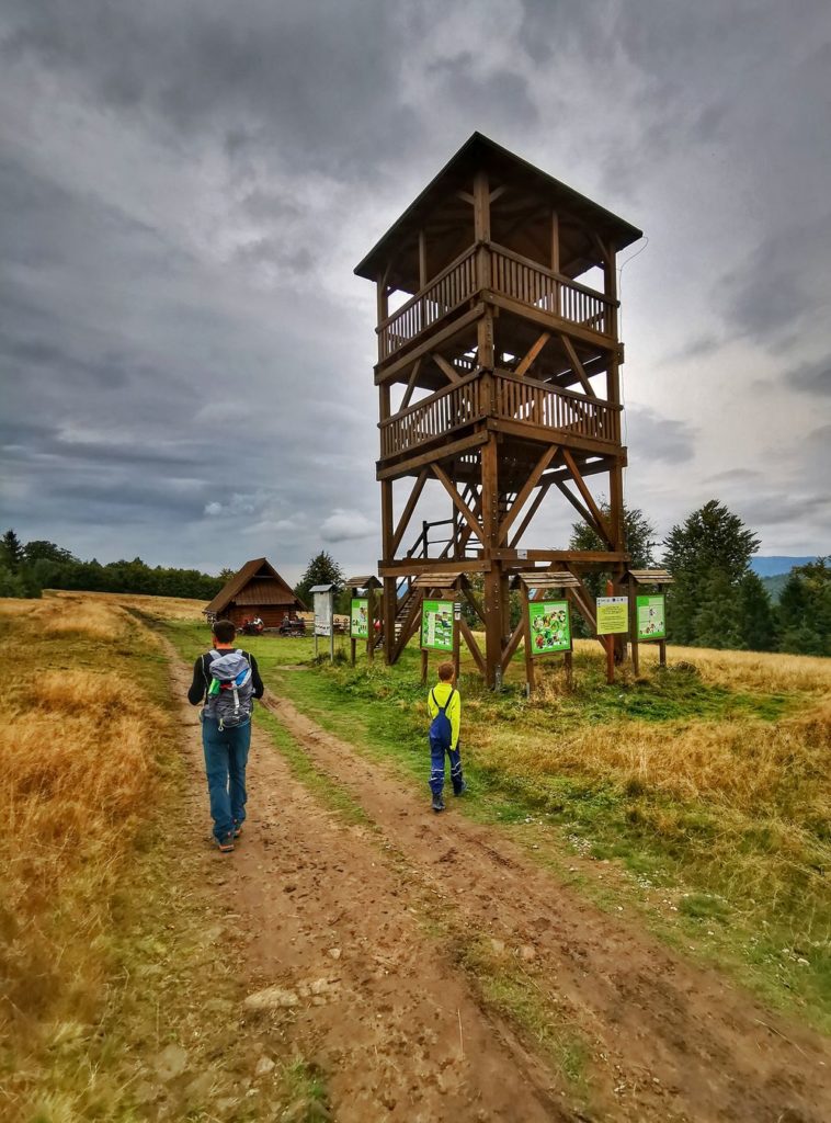 Turysta z dzieckiem, dwunastometrowa drewniana wieża widokowa - Stary Groń, Brenna, ciemne niebo
