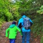 Turyści - mężczyzna z dzieckiem, leśna, kamienista droga