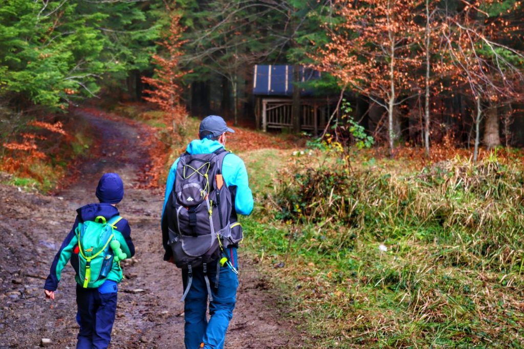 Turyści - dziecko z tatą na szerokiej drodze leśnej w Beskidzie Małym, leśny paśnik dla zwierząt