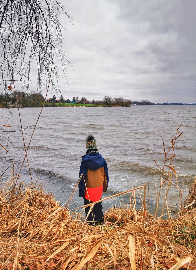 Dziecko stojące nad brzegiem Jeziora Goczałkowickiego w Wiśle Małej, pochmurne popołudnie