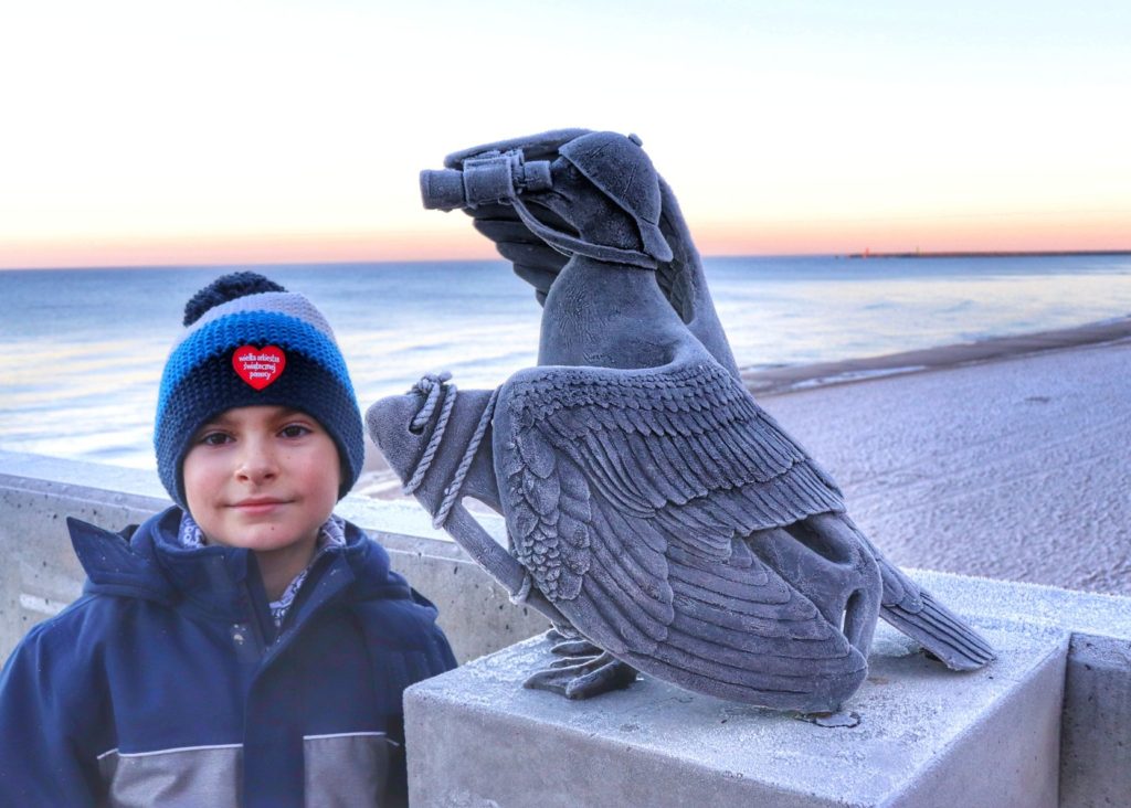 Uśmiechnięte dziecko, rzeźba mewy w Kołobrzegu - Marian Ratownik o wschodzie słońca