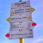 Zwardoń, biała tablica z napisem POLANA (808 m n.m.), drogowskazy, szlak czerwony