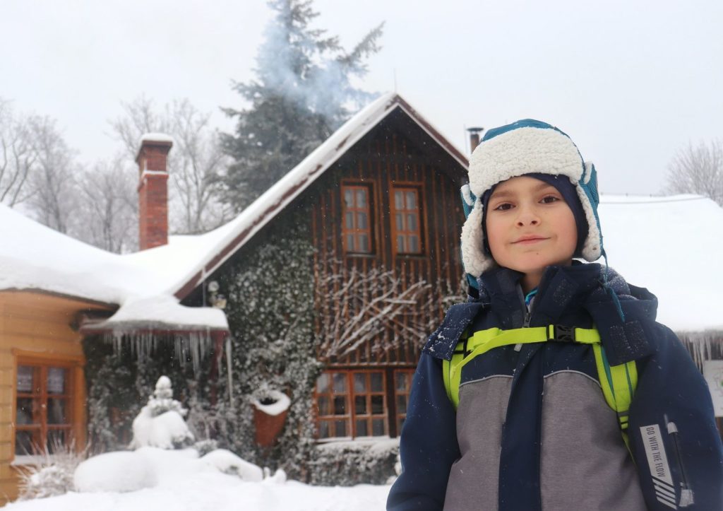 Uśmiechnięte dziecko na tle schroniska Stefanka - Kozia Góra - zima