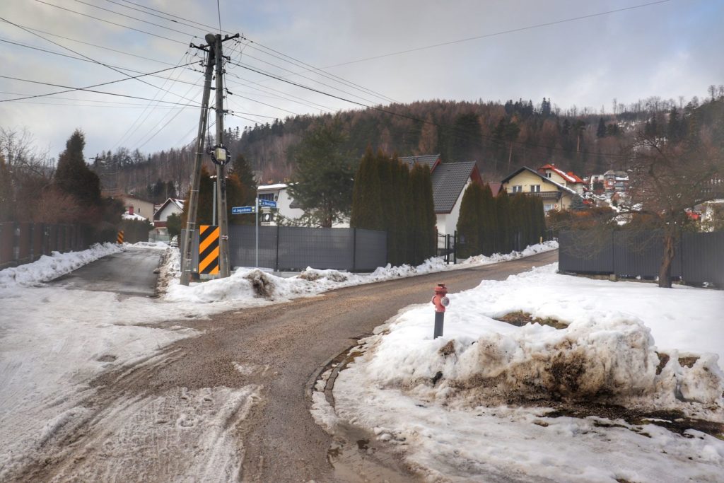 Rozwidlenie drogi na czerwonym szlaku w Bystrej Śląskiej - szlak czerwony skręca w tym miejscu w prawo na ulicę Beskidzką, zabudowania