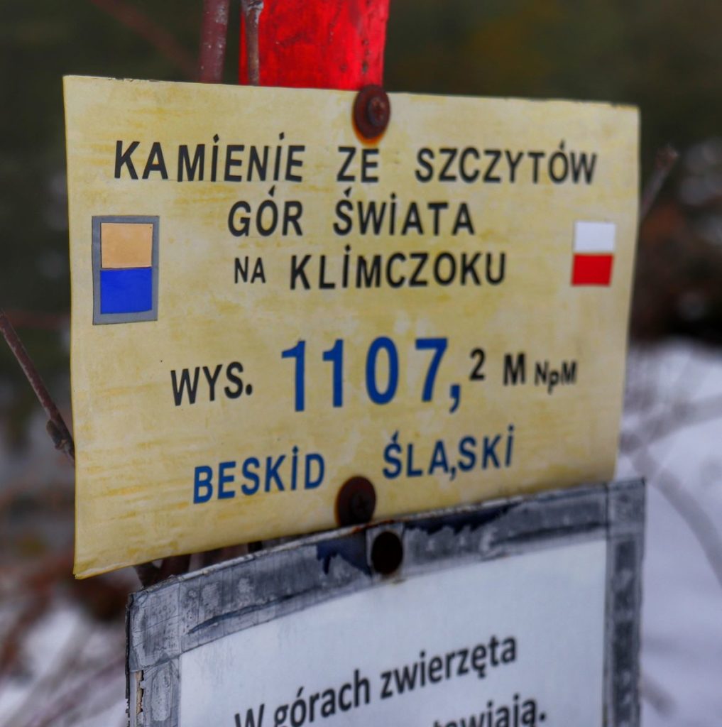Szczyt Klimczok - żółta tabliczka z napisem - Kamienie ze szczytów gór Świata na Klimczoku
