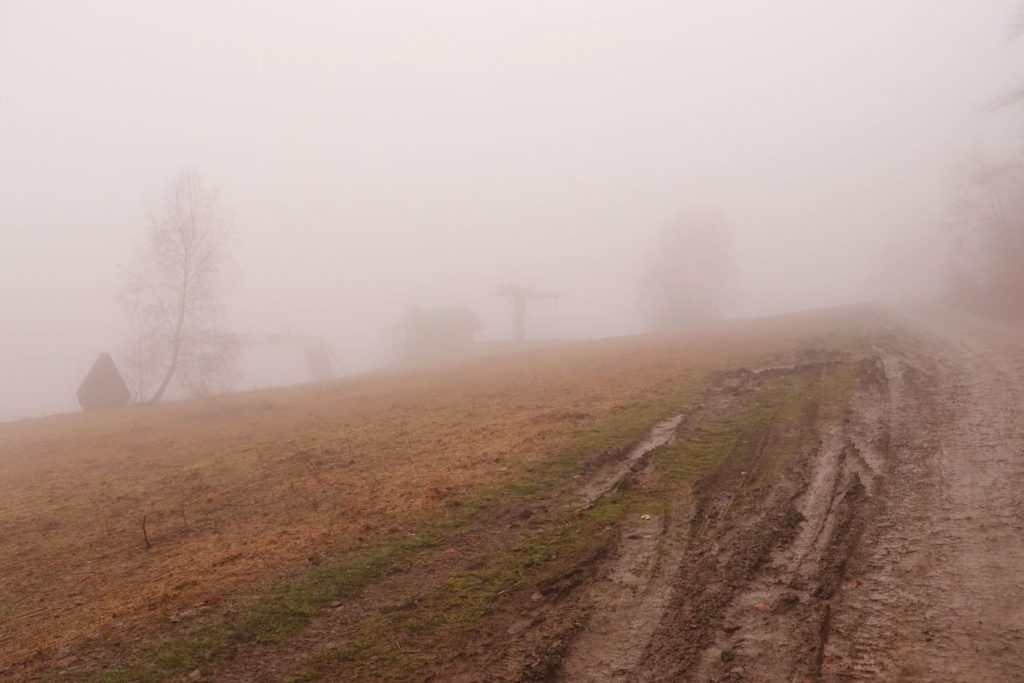Pnąca się w górę droga na niebieskim szlaku na Soszów Wielki, mgła, wyciąg, drewniana chatka
