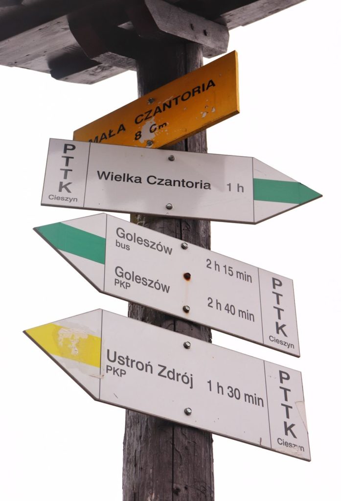 Słup z drogowskazami, żółta tabliczka z napisem - Mała Czantoria 866 m n.p.m.