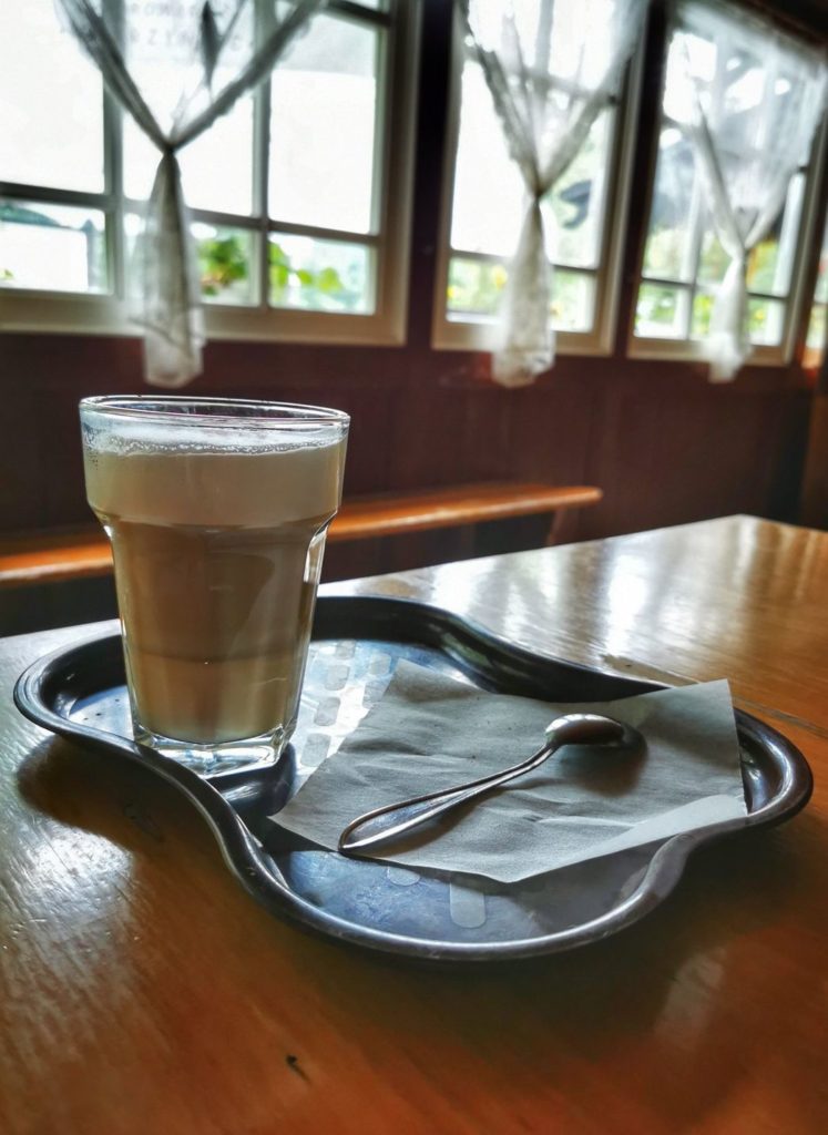 Szklanka z kawą latte, wnętrze Schroniska na Soszowie