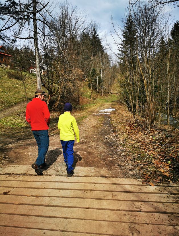 Turysta z dzieckiem przechodzący przez drewniany mostek - Złatna Huta - droga do wodospadu w Złatnej