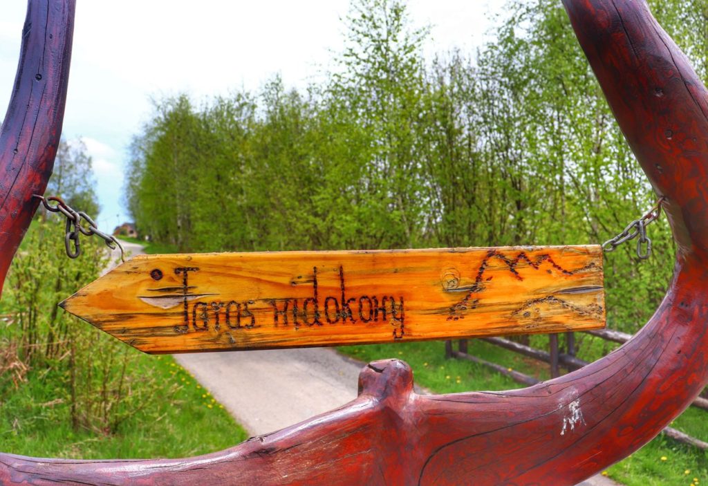 Drewniana tabliczka wskazująca kierunek na taras widokowy Ścieszków Groń