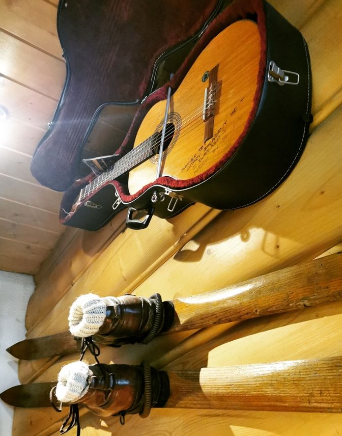 Gitara, stare narty wiszące na ścianie w sali kominkowej w Schronisku pod Durbaszką w Małych Pieninach