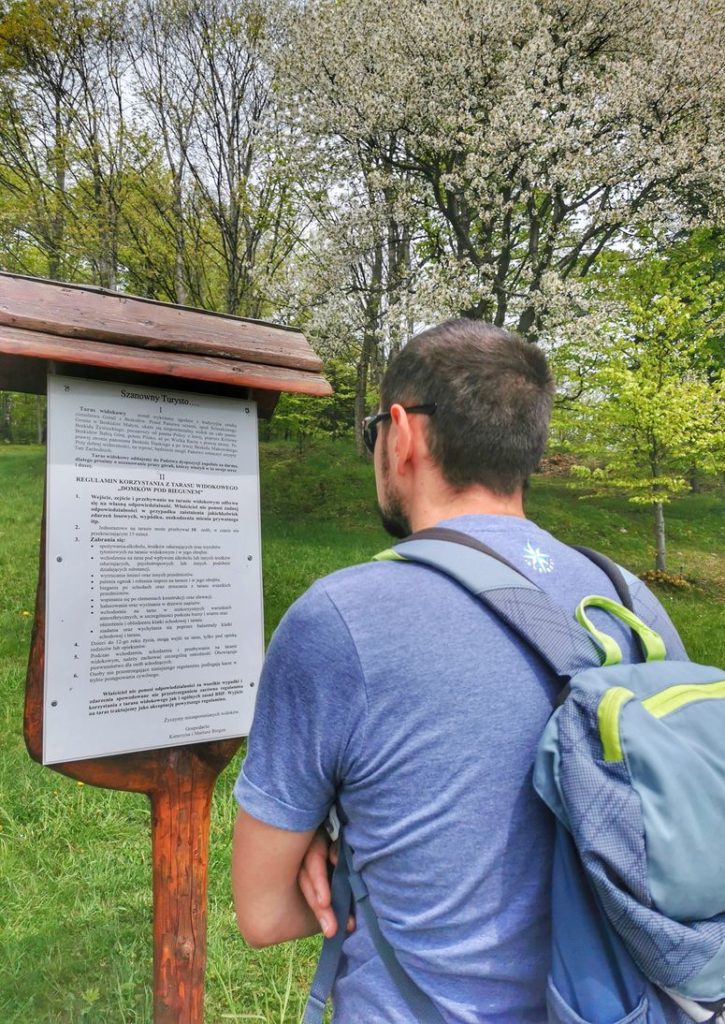 Turysta czytający regulamin tarasu widokowego Ścieszków Groń - Łysina