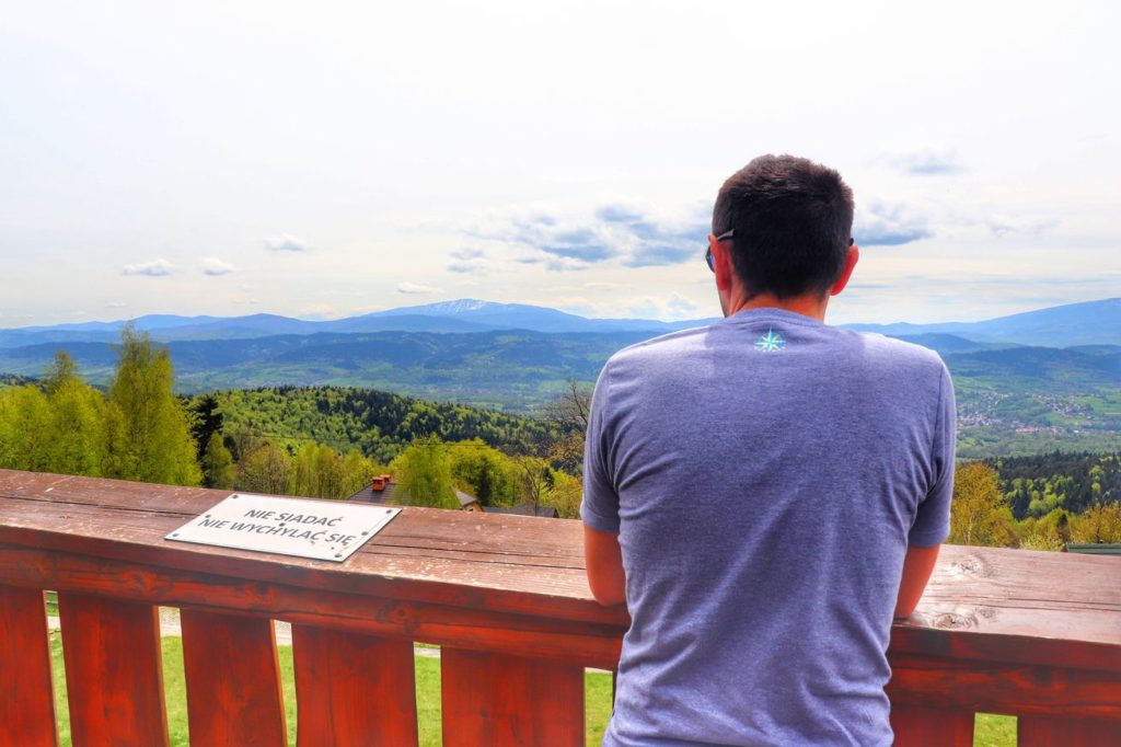 Turysta podziwiający widoki z wieży widokowej na Łysinie w Beskidzie Małym, widok na Babią Górę