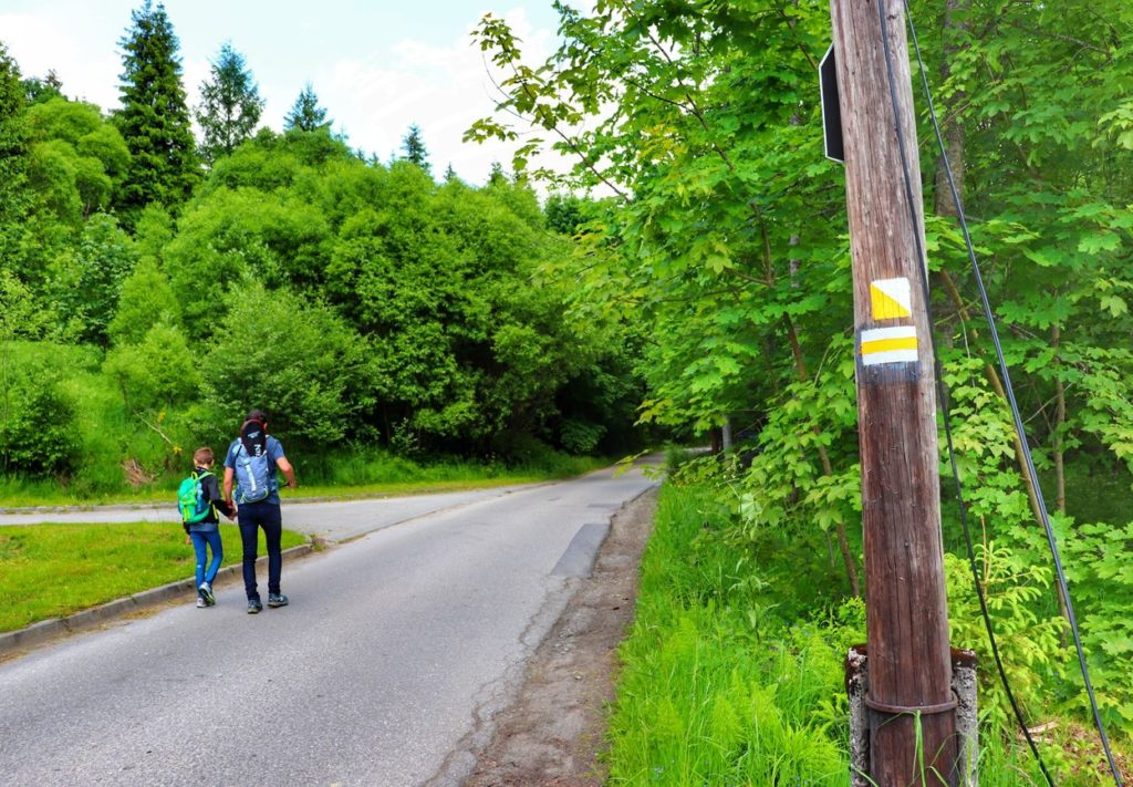 Asfaltowa droga w Istebnej na szlaku żółtym i szlaku żółtym spacerowym, turysta z dzieckiem
