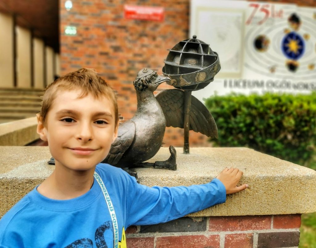 Marian Kopernikański - pomnik mewy - Kołobrzeg - uśmiechnięte dziecko pozujące przy rzeźbie