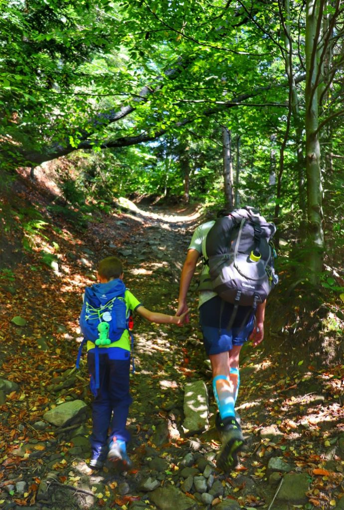 Podejście prowadzące przez gorczański las, kamienista ścieżka, turysta z dzieckiem