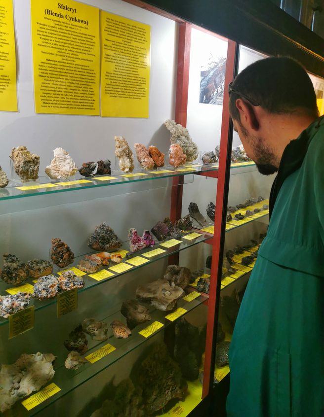 Turysta w Muzeum Minerałów w Szklarskiej Porębie, gablotki z eksponatami