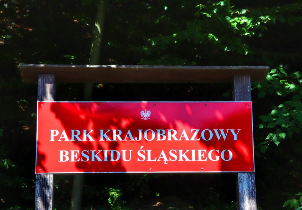 Czerwona tablica z białym napisem - Park Krajobrazowy Beskidu Śląskiego, Dolina Zimnika, Lipowa