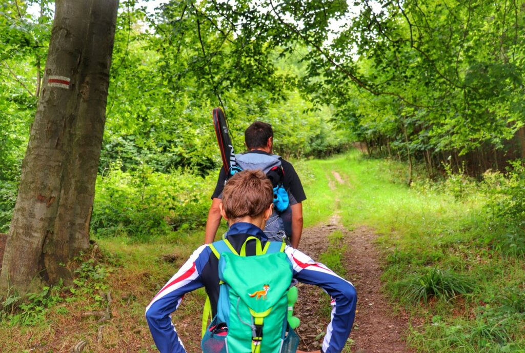 Turyści - mężczyzna z dzieckiem, podejście przez las na czerwonym szlaku w Zwardoniu