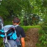 Turysta, leśna, kamienista ścieżka na czerwonym szlaku na Rachowiec