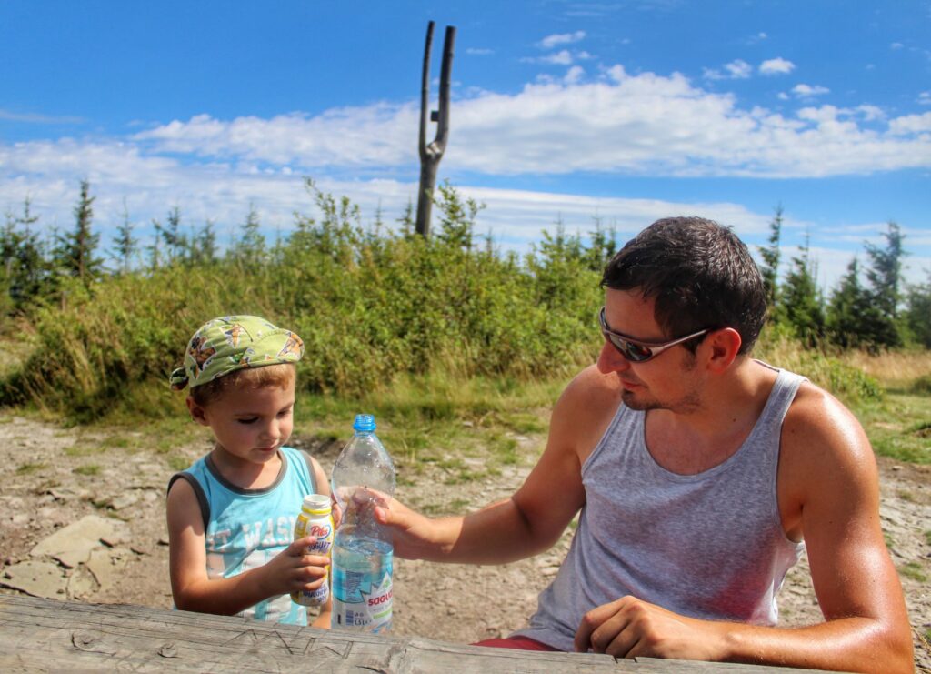 Turysta z dzieckiem odpoczywający na szczycie Skrzyczne w Beskidzie Śląskim