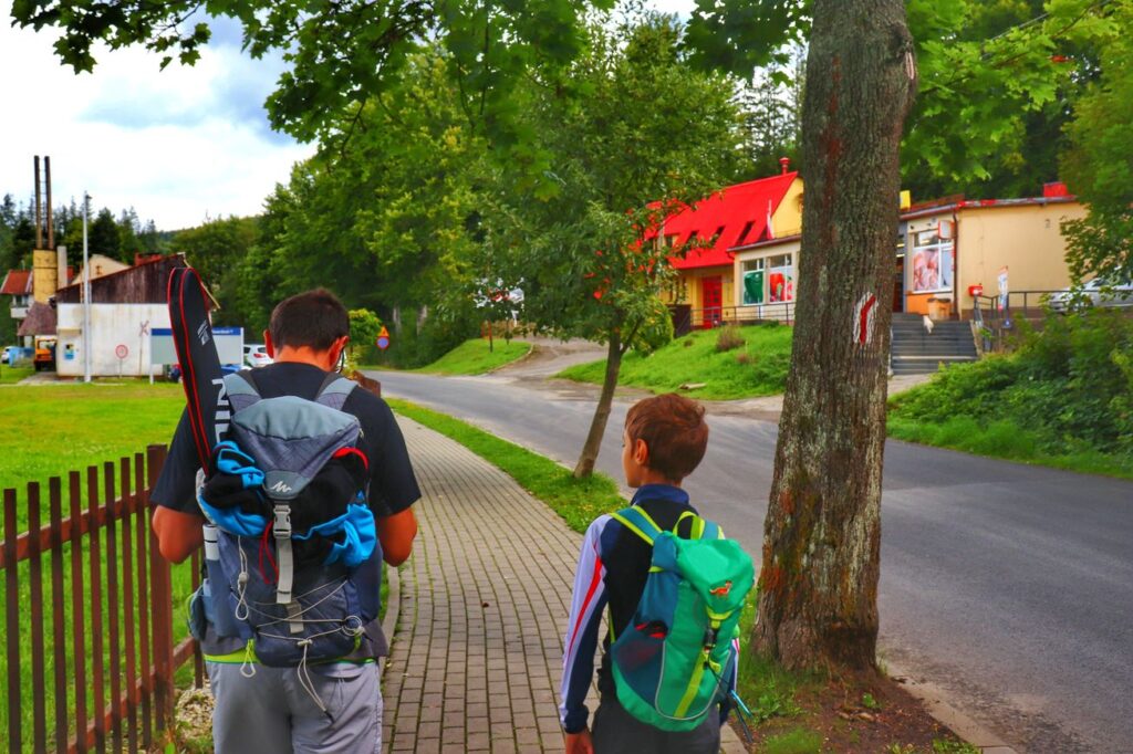 Zwardoń - okolica stacji kolejowej, turysta z dzieckiem na czerwonym szlaku turystycznym