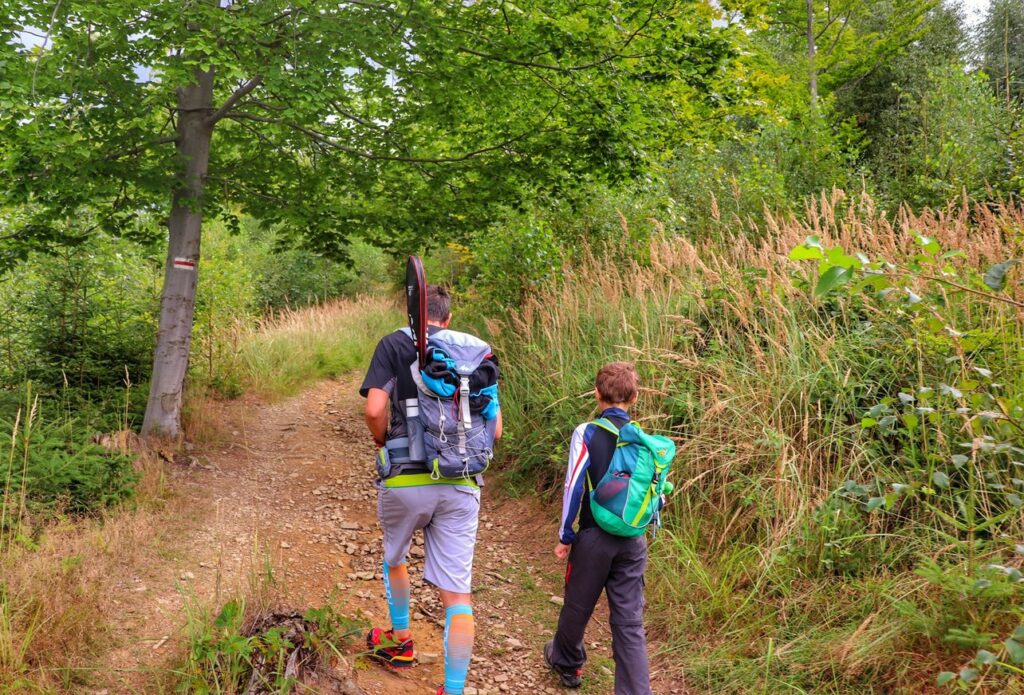 Turysta z dzieckiem, podejście przez las, szlak czerwony - Zwardoń