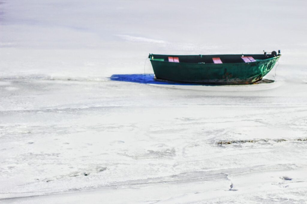 Pokryte lodem Jezioro Żywieckie, łódka