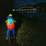 Późny wieczór, dziecko na rowerze, oświetlony most w Żywcu