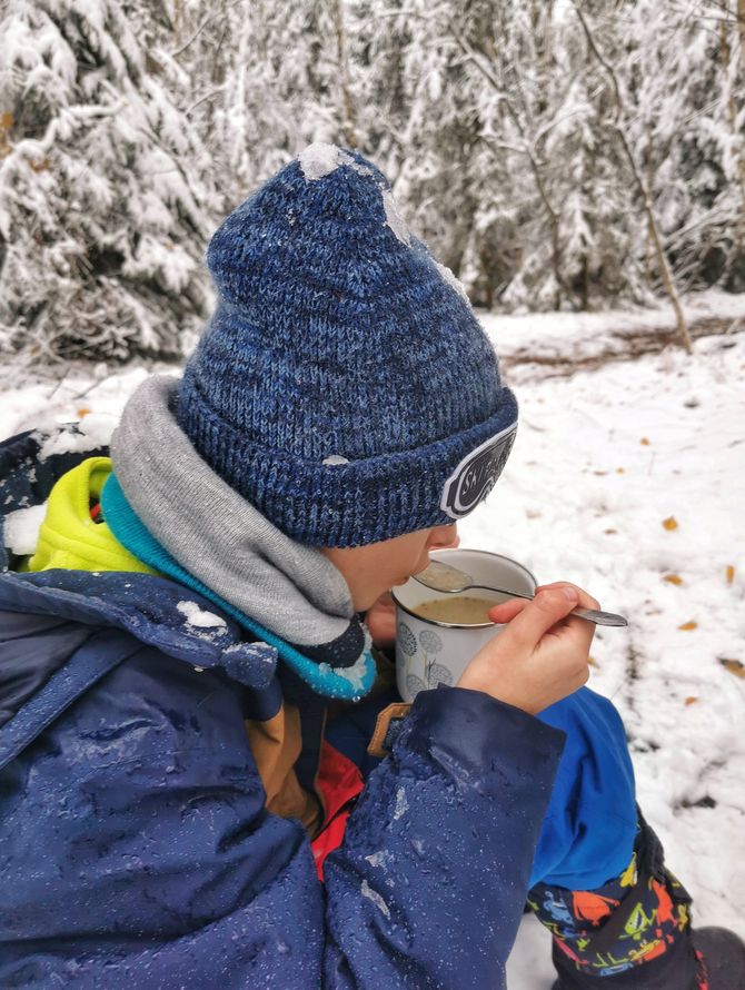 Mały turysta - dziecko jedzące zupę - żurek w lesie, śnieg