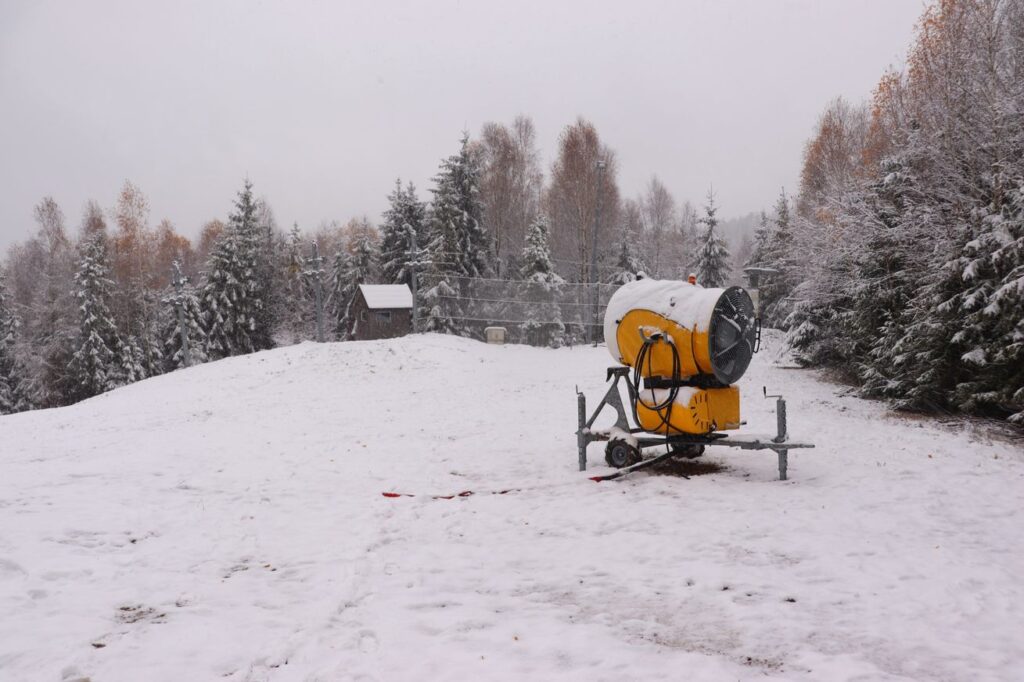 Stok w Wiśle na niebieskim szlaku, armatka śnieżna, w oddali drewniany domek