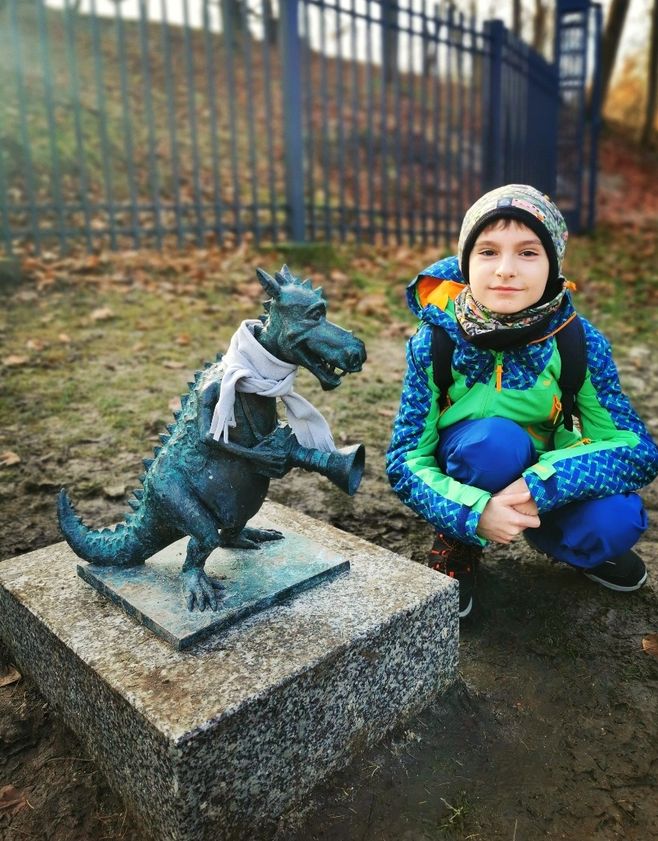 Uśmiechnięte dziecko przy rzeźbie smoka, SMOK Turysta w Krakowie 