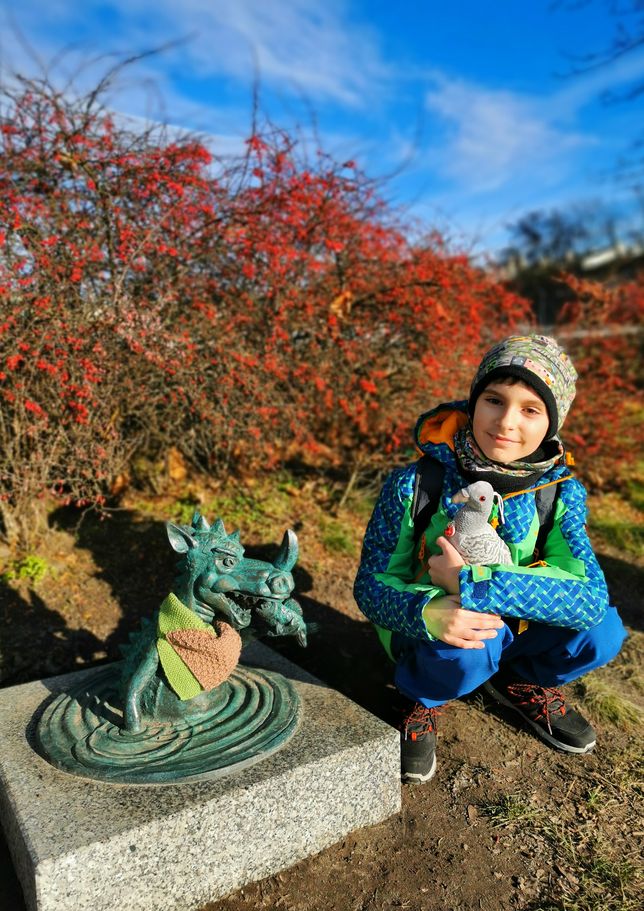 Uśmiechnięte dziecko przy rzeźbie smoka - smok wodny w Krakowie