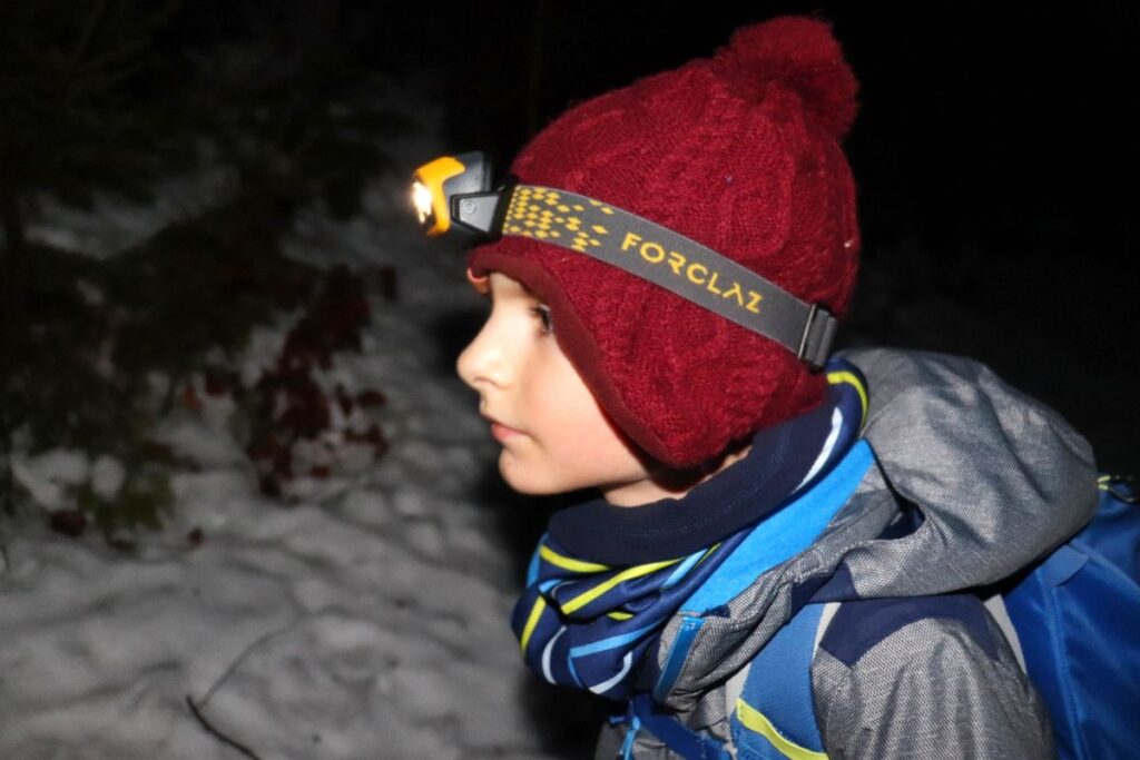 Mały turysta, dziecko z latarką po zmroku na beskidzkim szlaku, śnieg