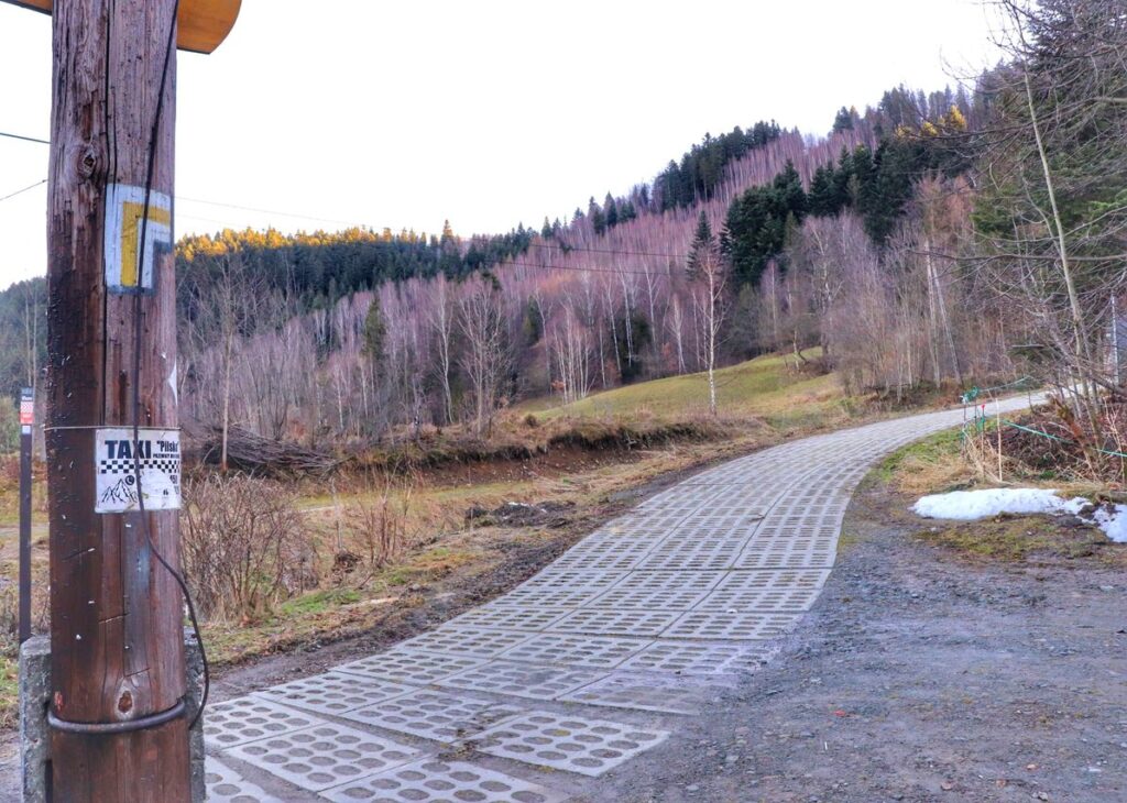 Miejsce skrętu szlaku żółtego w Sopotni Wielkiej prawo, droga wyłożona betonowymi płytami