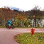 Rowerzysta, miejsce skrętu szlaku zielonego rowerowego wokół jeziora w prawo