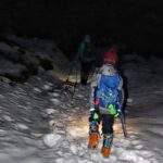 Turysta z dzieckiem, zmrok na szlaku, zima, latarki