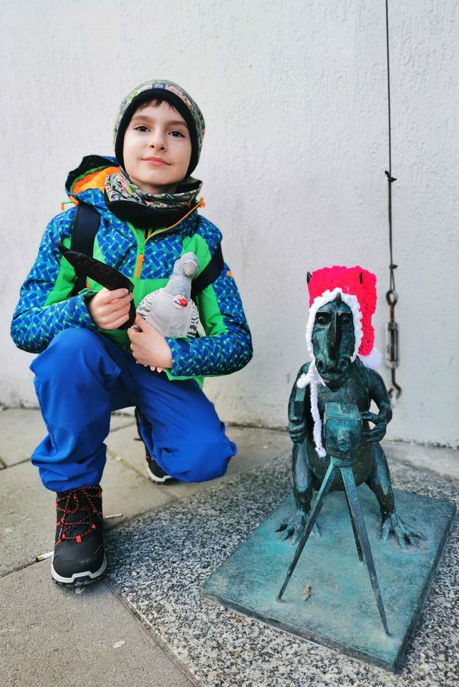Uśmiechnięte dziecko, figurka smoka - smok filmowiec w Krakowie 