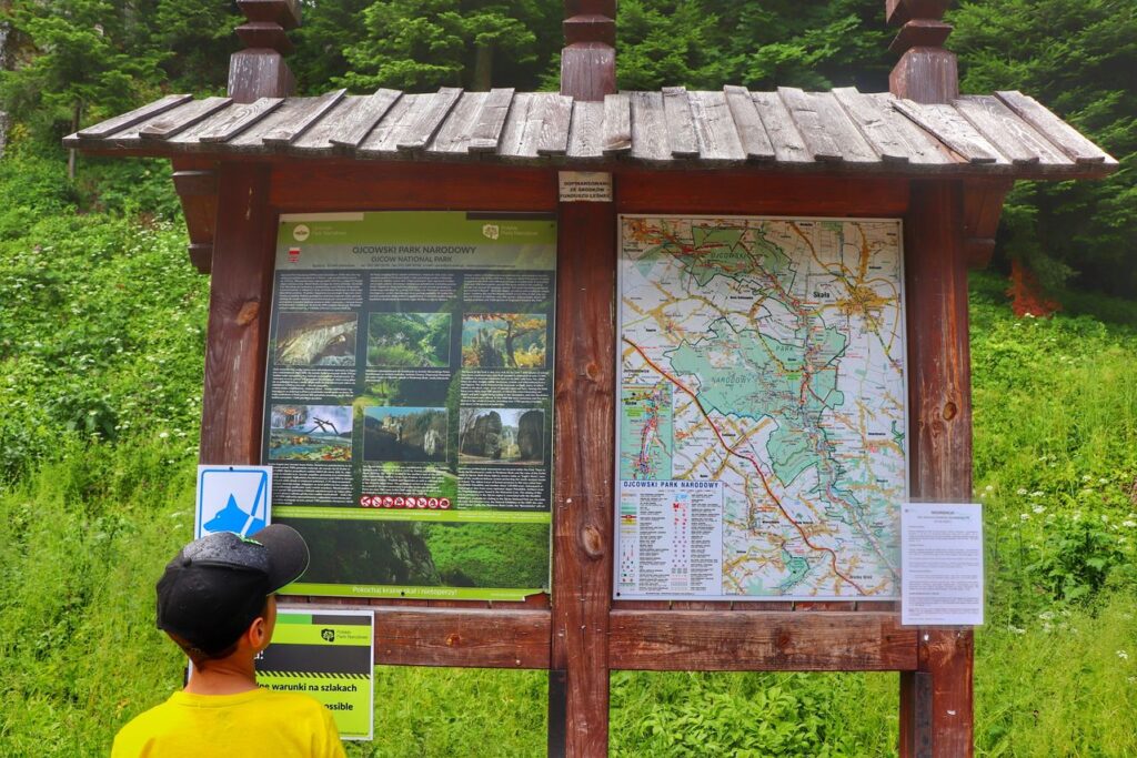 Dziecko, tablica informacyjna z mapą w Ojcowskim Parku Narodowym