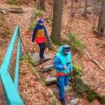 Turysta z dzieckiem schodzący do jaskini Skalna Komora znajdującej się przy szlaku żółtym na Górę Witosza