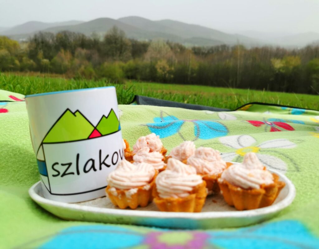 Polana widokowa - Bucze, babeczki z kremem, kubek z kawą, w tle krajobraz górski