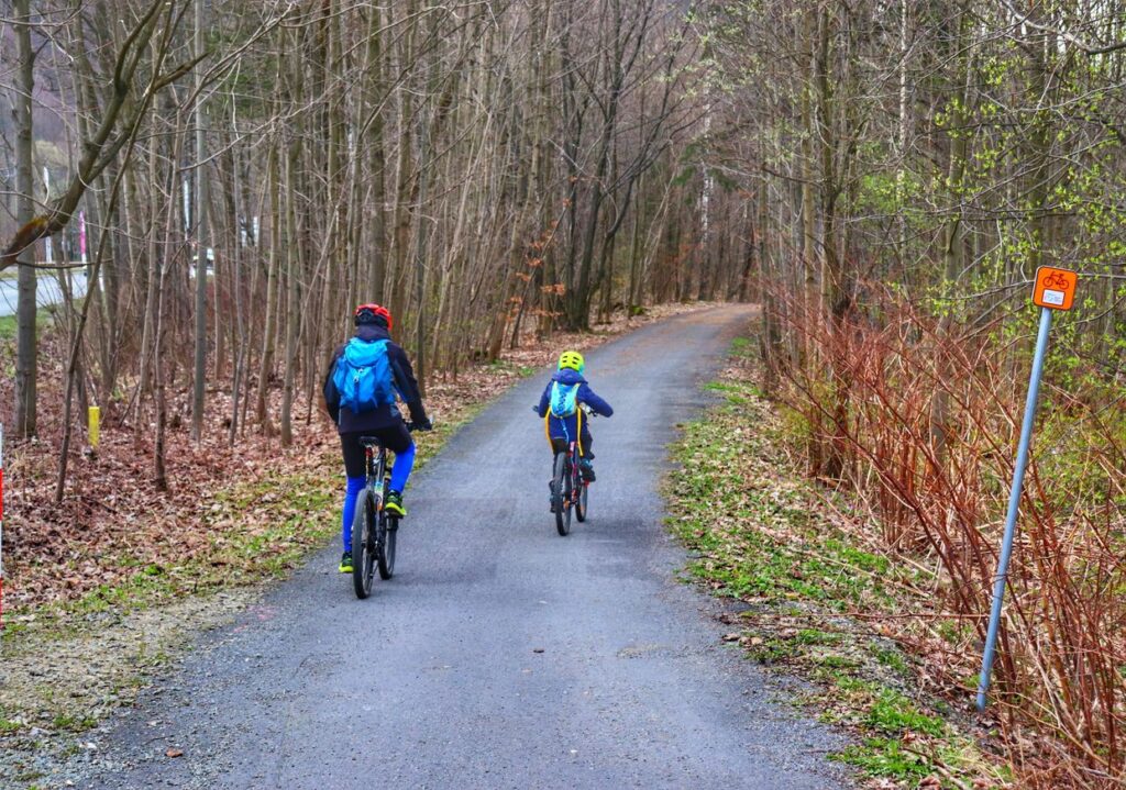 Rowerzyści, dziecko z tatą, ścieżka rowerowa na szlaku czerwonym w Ustroniu