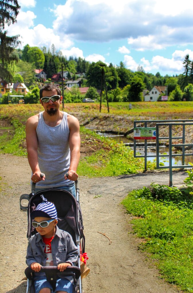 Turysta z dzieckiem w wózku w mieście Wisła na ścieżce pieszo-rowerowej