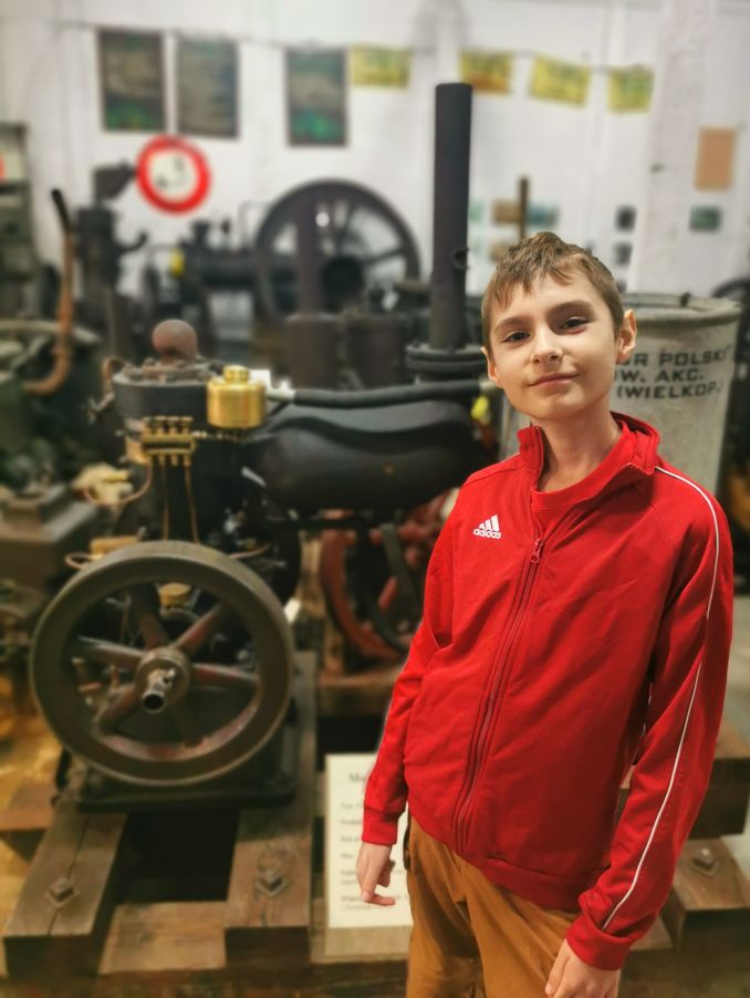 Muzeum Silników Stacjonarnych i Techniki Rolniczej w Konieczkowej, uśmiechnięte dziecko, w tle silniki