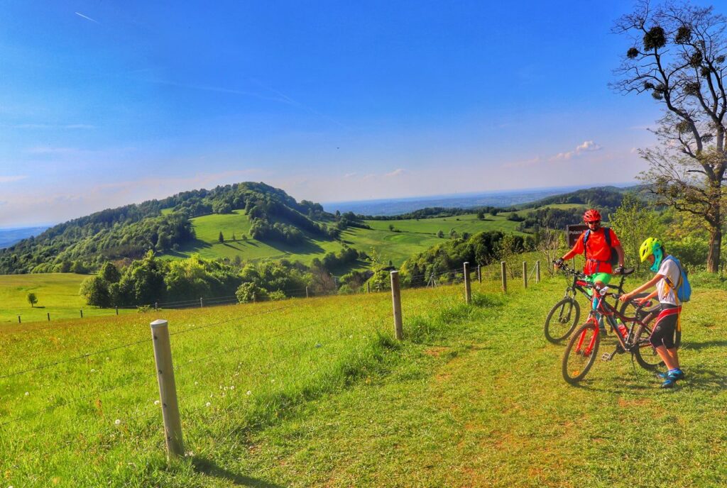 Polana Budzin w Beskidzie Śląskim, rowerzyści - dziecko z tatą, piękny i słoneczny dzień, zielona trawa