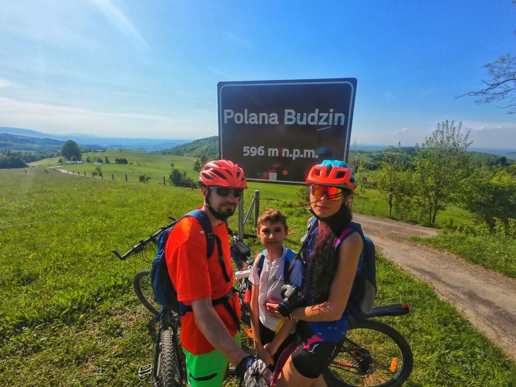 Szczęśliwa rodzina na rowerach na Polanie Budzin, słoneczny dzień, niebieskie niebo