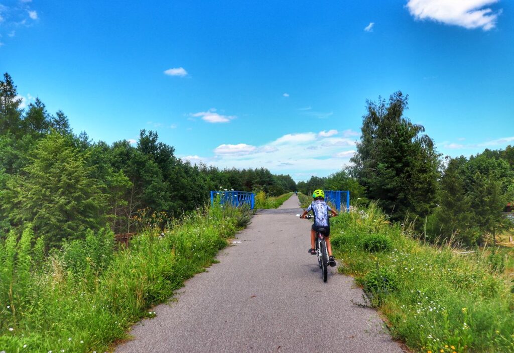 Dziecko na rowerze, mostek na trasie rowerowej Rowerem po Kolei