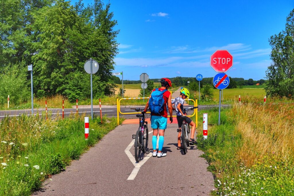 Rowerzyści na trasie Rowerem po Kolei na Mazurach, barierki